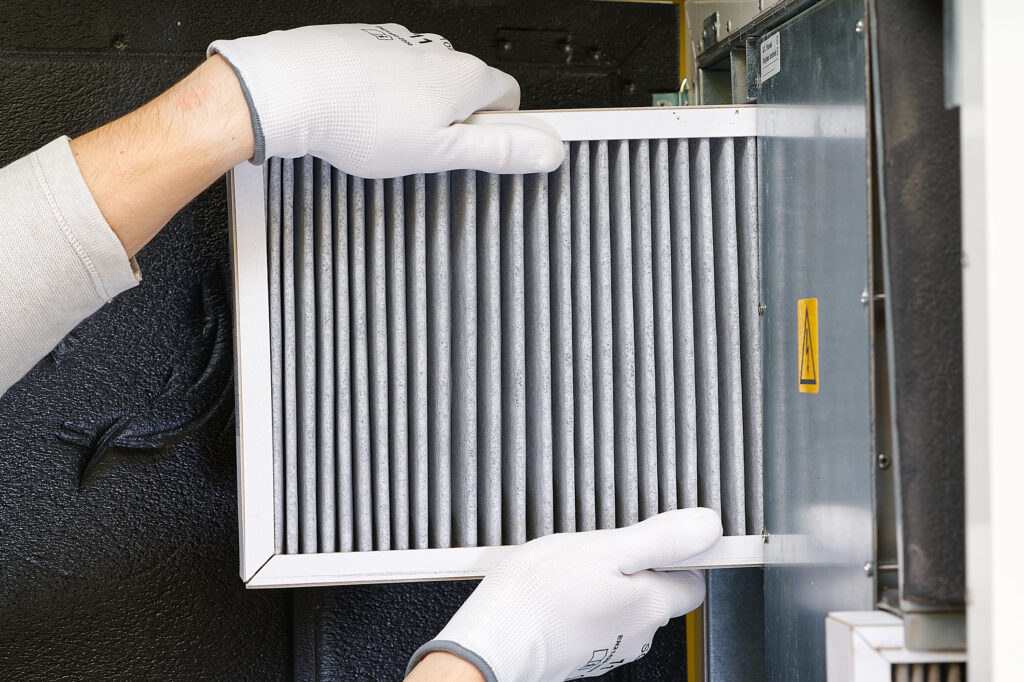 A technician replacing the air filter of an HVAC system