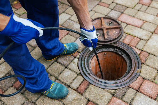 worker clearing a clogged drain with hydro jetting