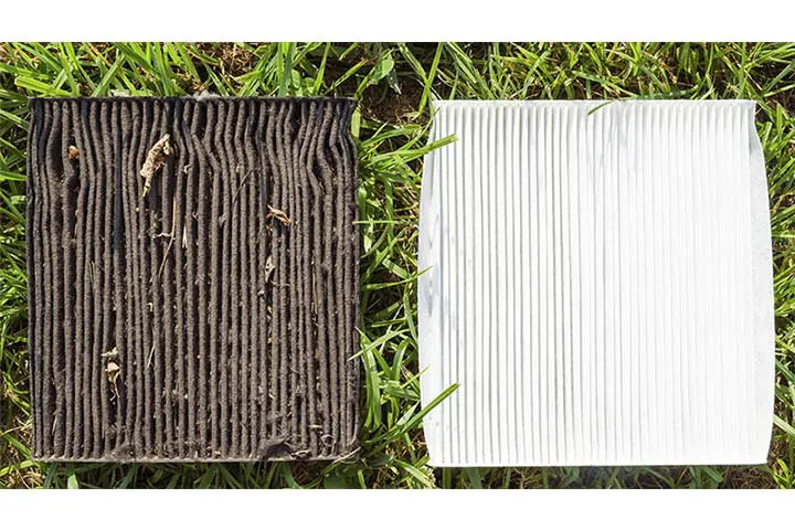 Two air filters are laying on the grass. The one on the left is old and dirty, and the one on the right in white and clean.