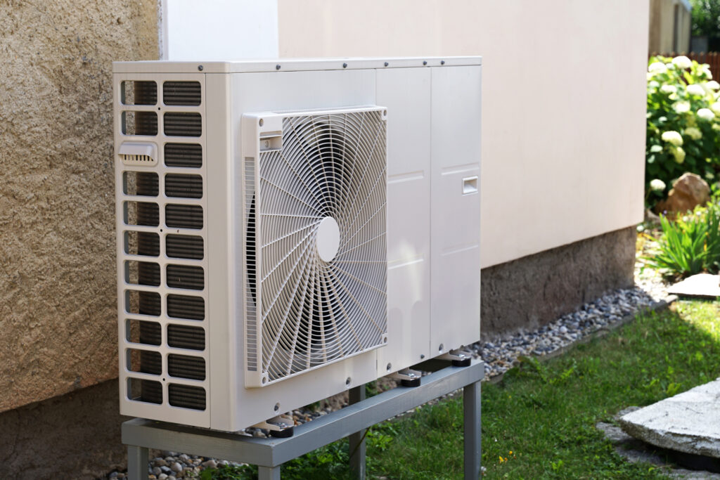 Heat pump outdoor unit outside a modern house.