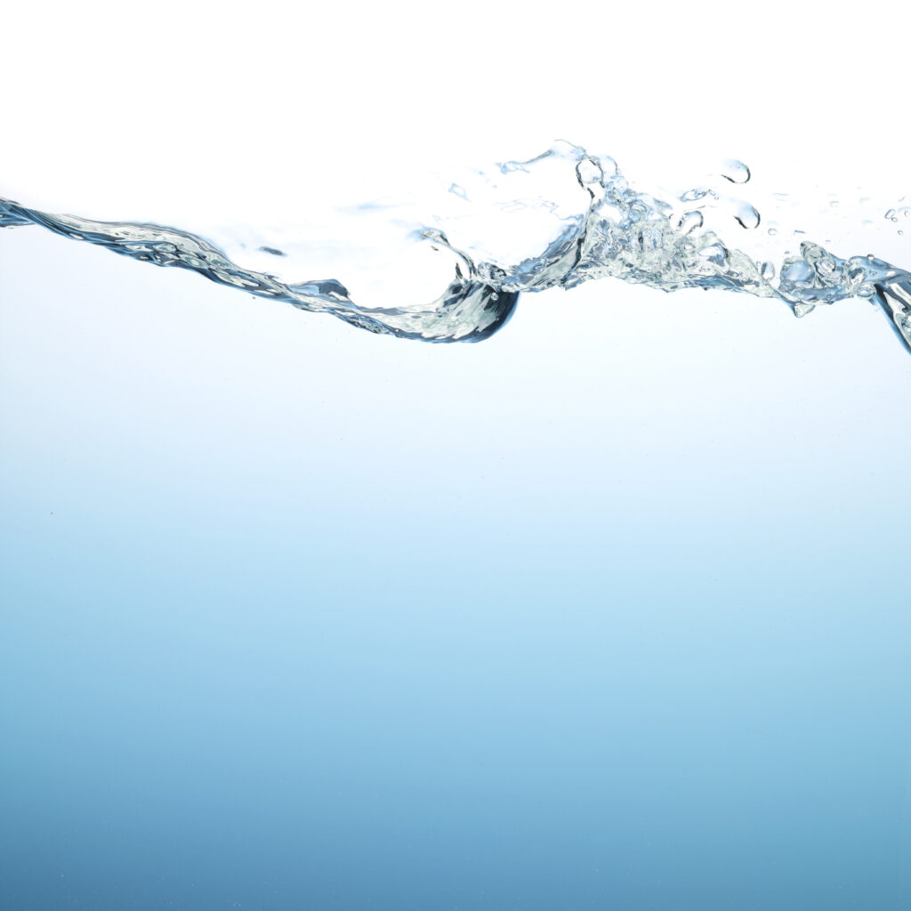 Side view of clear water with a blue background.