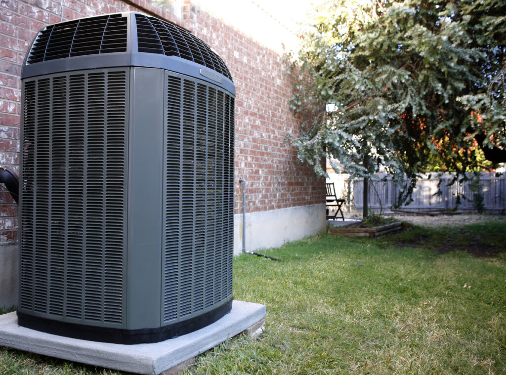 An HVAC unit outside a brick home