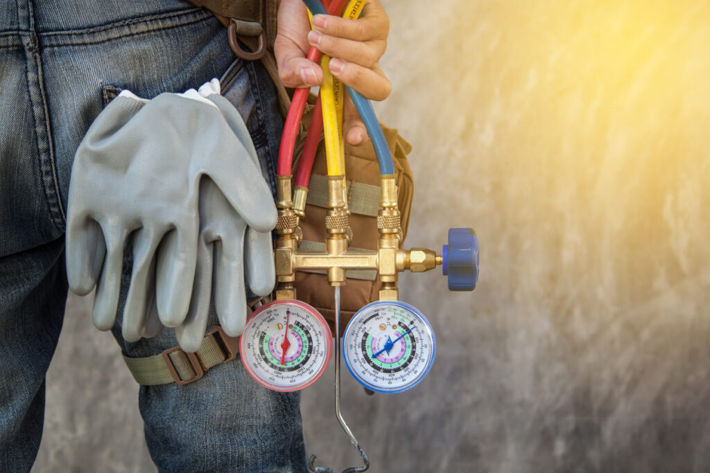 An HVAC technician with tools to assess an HVAC unit